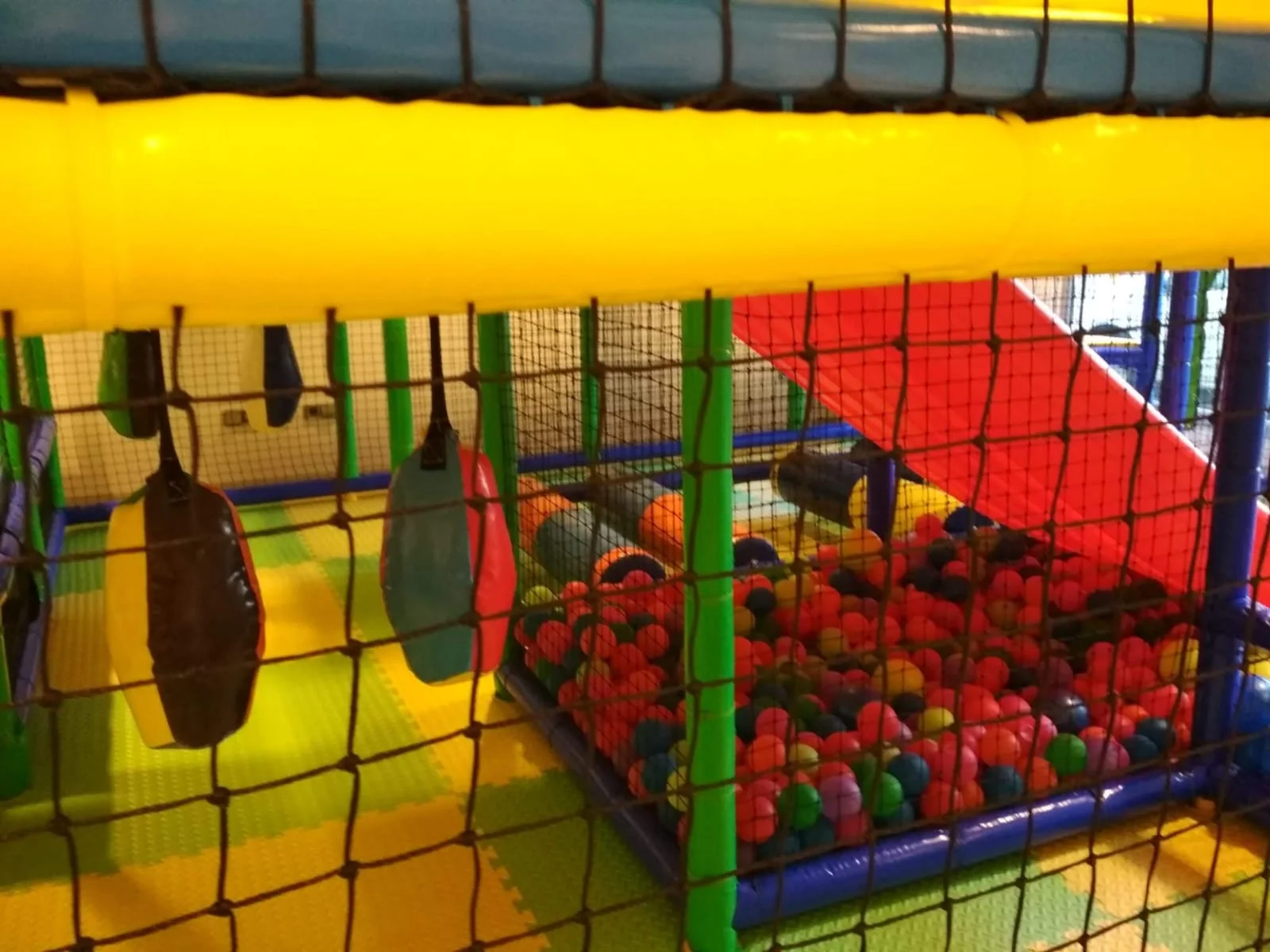 Juegos infantiles en parque de bolas con estructuras de escalada