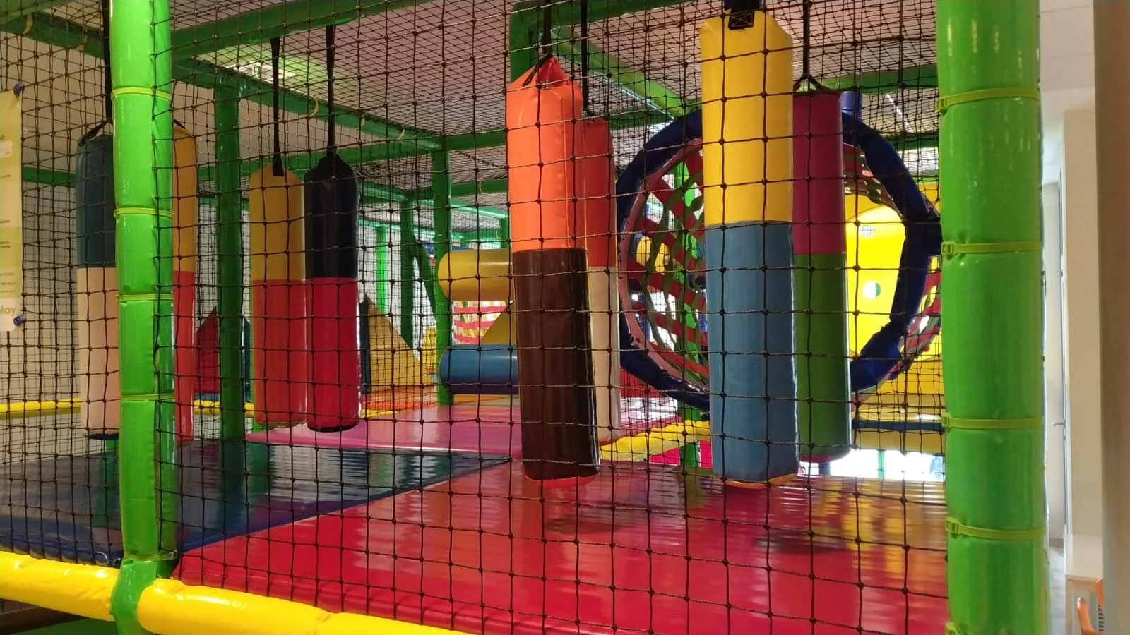 Diversión en parque infantil con columpios, toboganes y pelotas