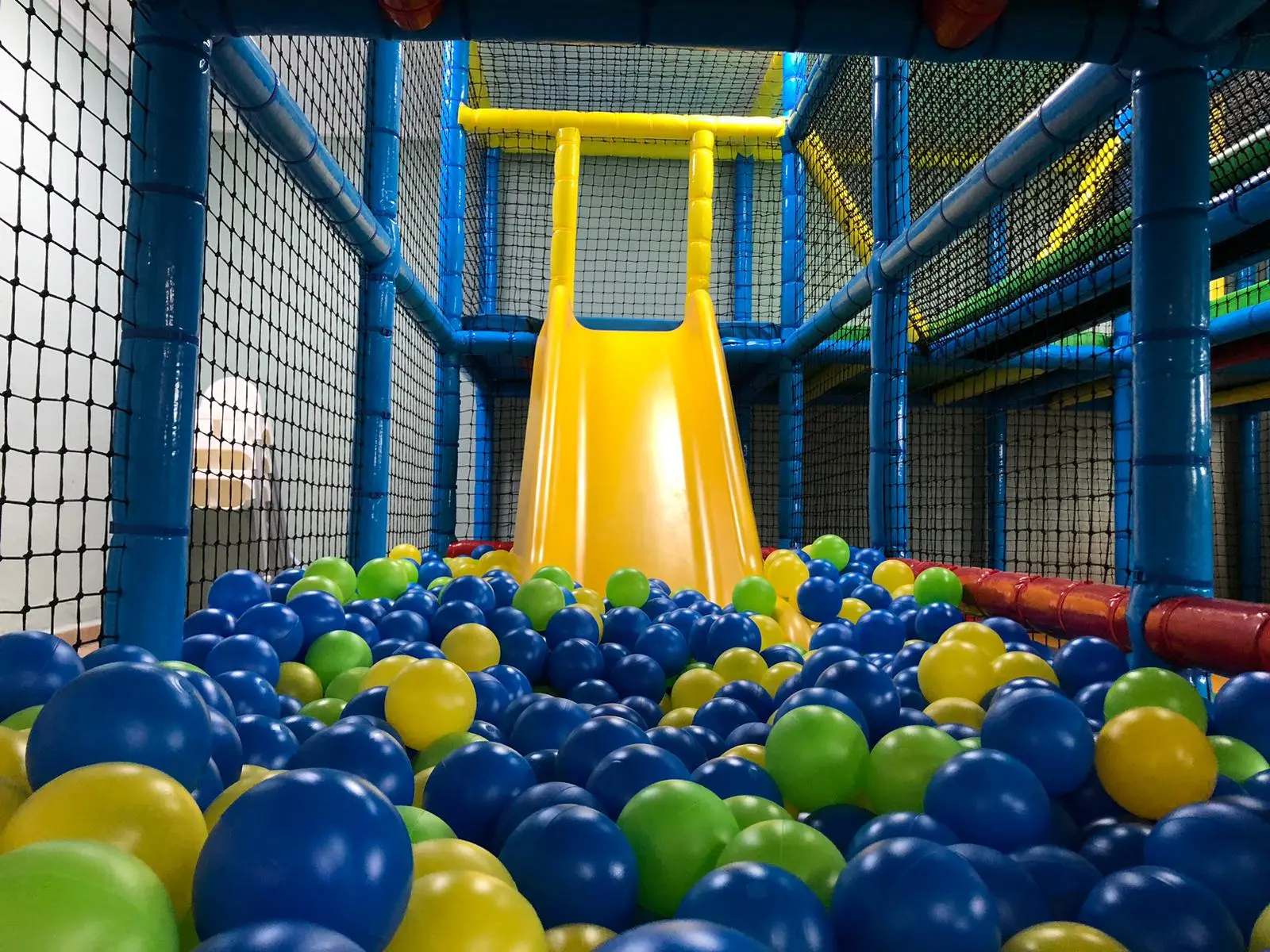 Tobogán con piscina de bolas en parque infantil seguro